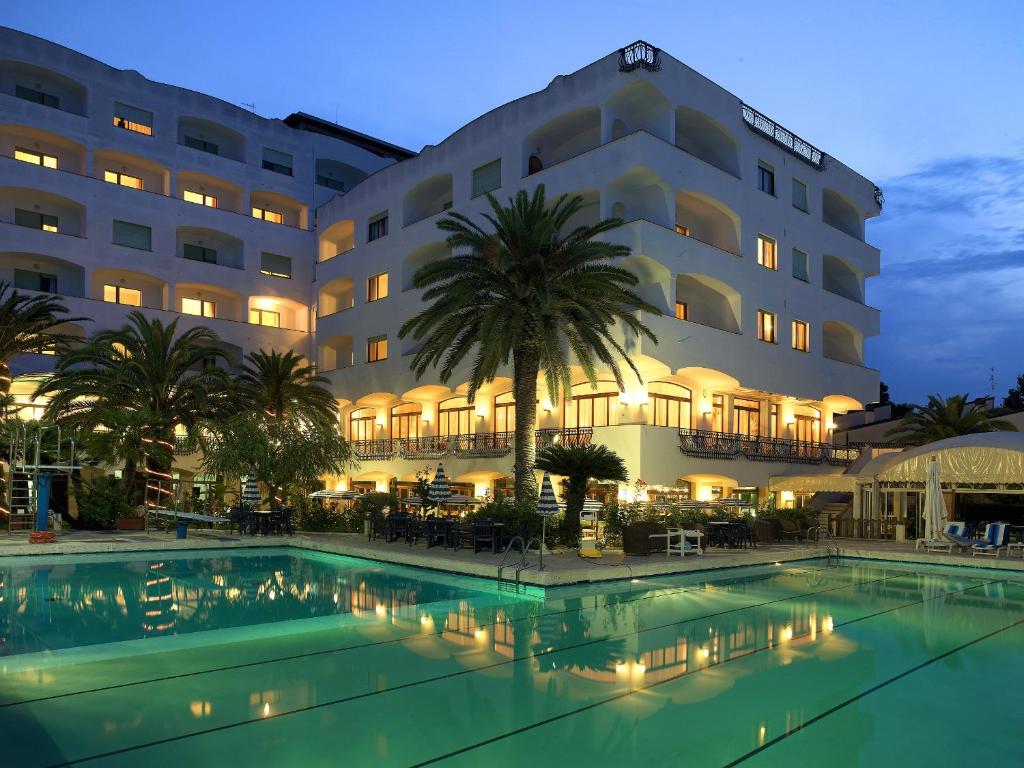 un hotel con piscina frente a un edificio en Grand Hotel Don Juan, en Giulianova