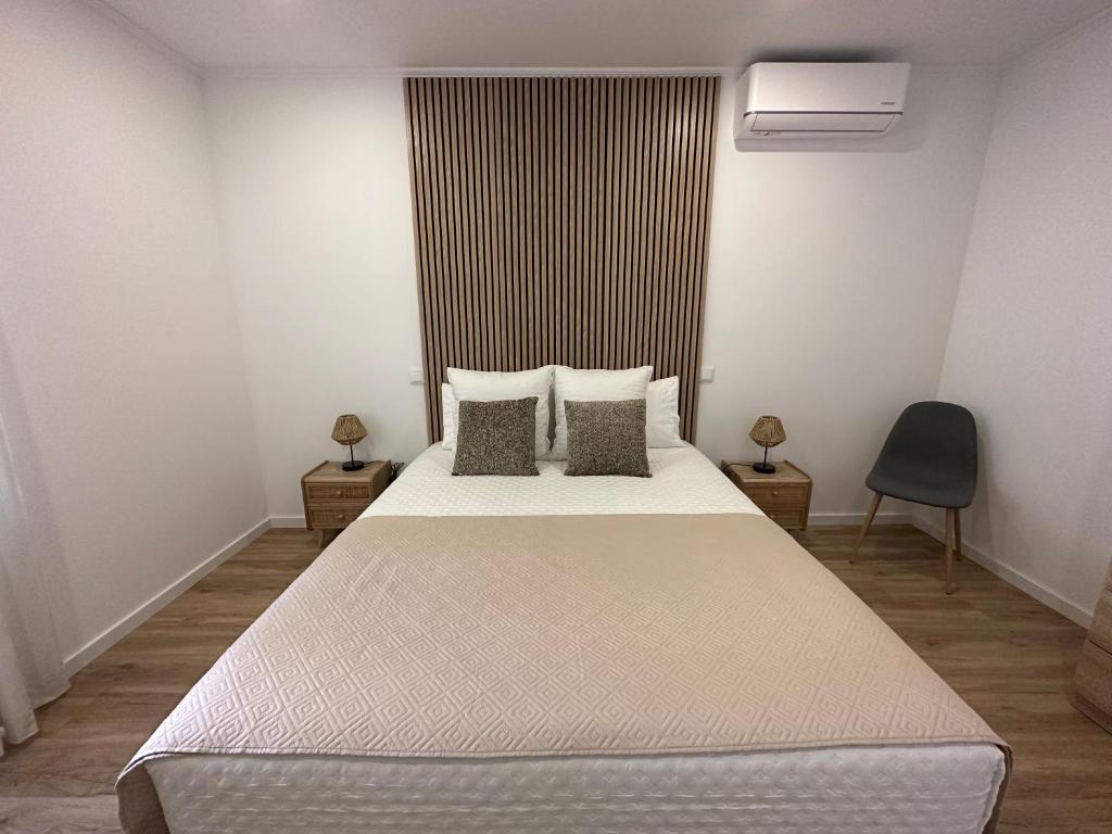 a bedroom with a large white bed with two pillows at Achadinha Sunset House in Achadinha