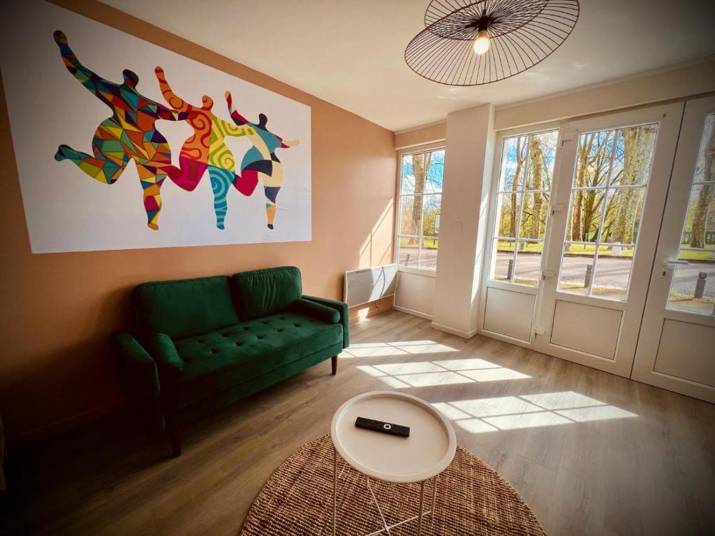 Una sala de estar con un sofá verde y una mesa. en Niki, belle vue sur le Loiret, en Saint-Pryvé-Saint-Mesmin