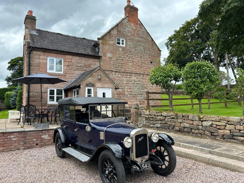 een oude blauwe auto geparkeerd voor een huis bij Character 3 Bed Peak District Farmhouse - Alton Towers, Christmas Markets, Polar Bears, Chatsworth in Cheadle
