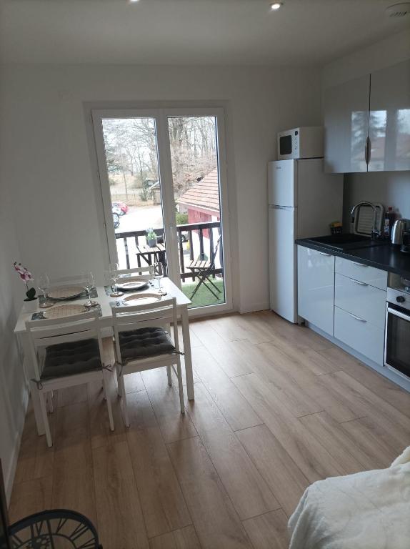 une cuisine avec une table et un réfrigérateur blanc dans l'établissement L'Escapade, à Thonon-les-Bains