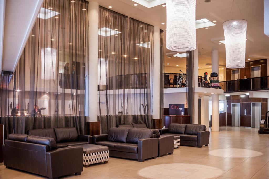 a lobby with couches and chairs in a building at West Plaza Hotel in Wellington