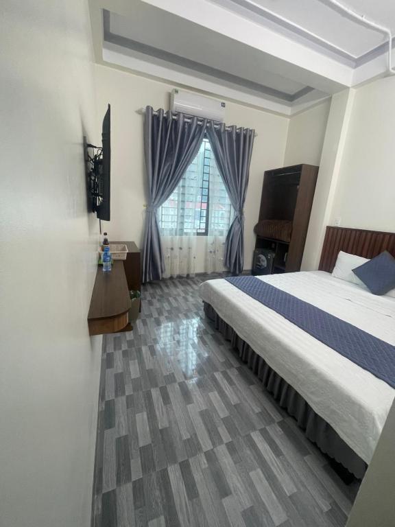 Un dormitorio con una cama grande y una ventana. en MINH HUY HOUSE Mộc Châu, en Mộc Châu