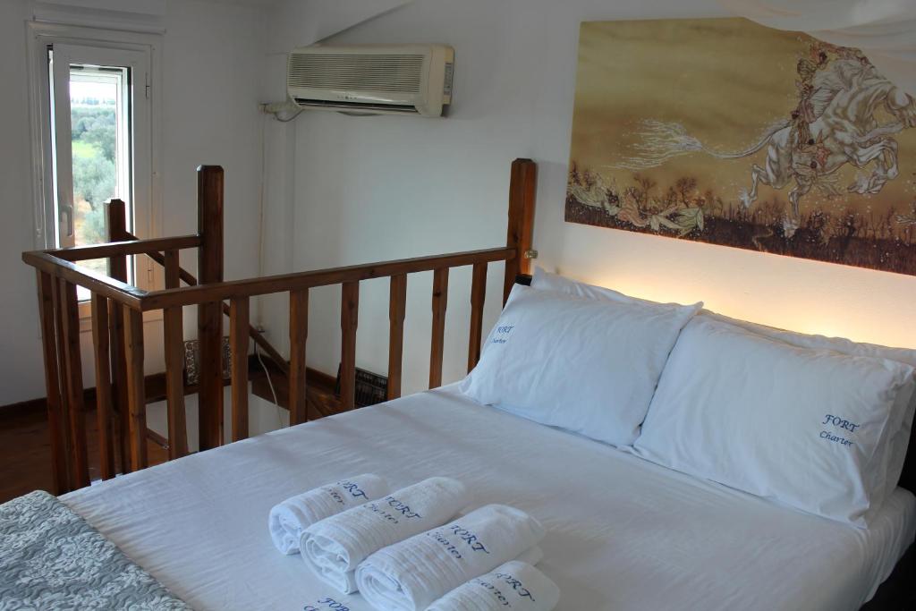 1 cama con 2 almohadas y una pintura en la pared en Olive Tree House II, en Dhermatiánika