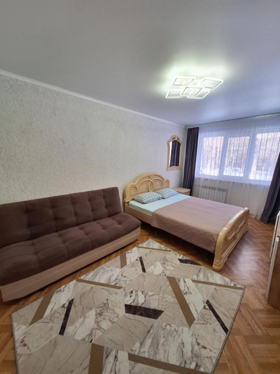 een woonkamer met een bed en een bank bij квартира in Balqash
