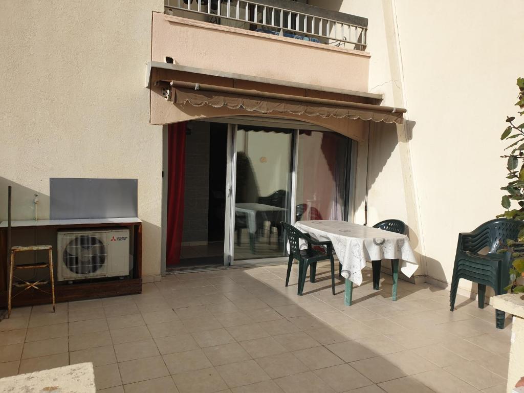 une salle à manger avec une table et des chaises et un balcon dans l'établissement T2 Cabine MARSEILLAN PLAGE, à Marseillan