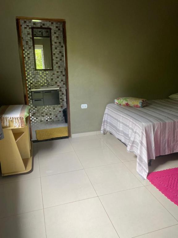 a bedroom with a bed and a mirror in it at Chalé do meio in Paraty