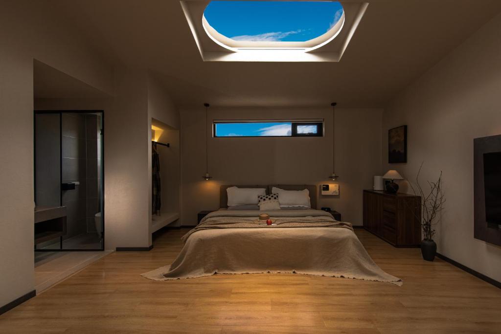 Un dormitorio con una cama grande y una ventana. en Shangri La Yi Shan Ban Yun Inn, en Shangri-La
