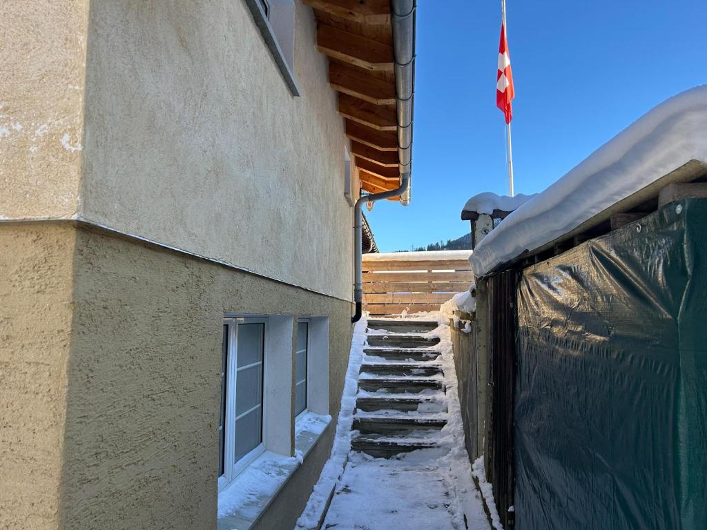 ein Gebäude mit Schnee auf dem Boden neben einem Gebäude in der Unterkunft Ferienwohnung Edelweiss, in Splügen