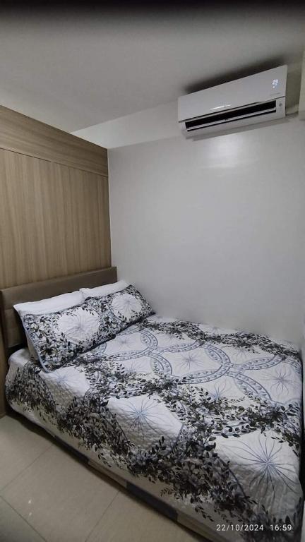 a bedroom with a bed with a black and white comforter at Shore 2 Tower 1 JMB Staycation in Manila