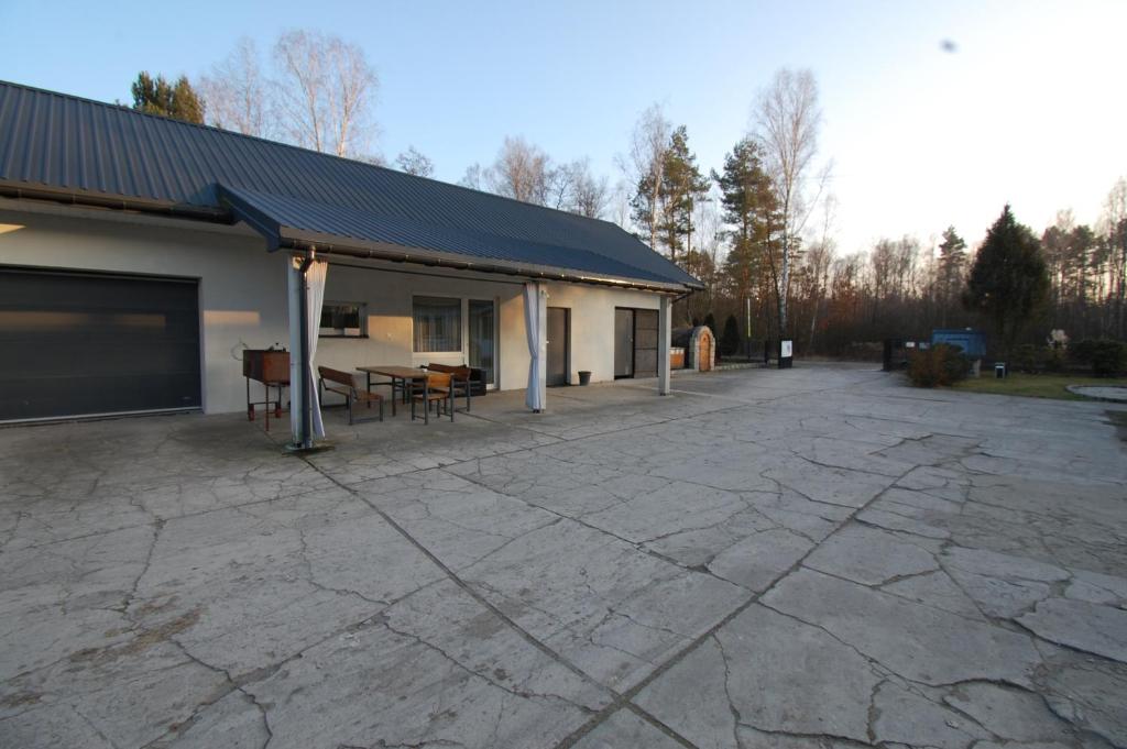 a patio with a table and chairs next to a building at Letnia Oaza "Forsycja" in Sobienie Jeziory