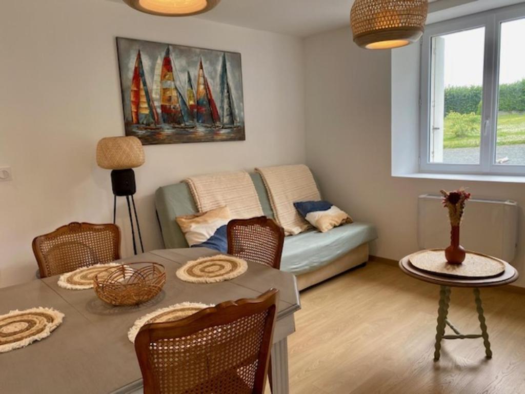 a living room with a table and a couch at Les Hauteurs du Trieux in Quemper-Guézennec