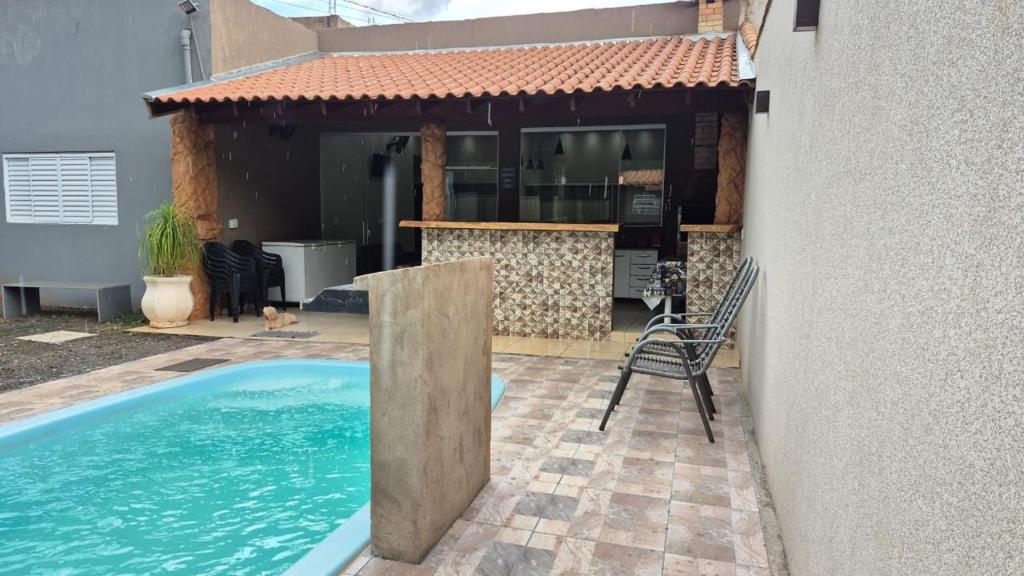 ein Haus mit einem Swimmingpool neben einem Gebäude in der Unterkunft Casa Colorado Thermas Laranjais Olimpia in Olímpia