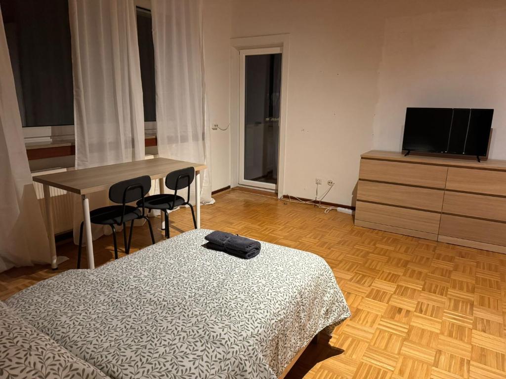 ハノーファーにあるApartment with three rooms and balconyのベッドと机とテレビのある寝室