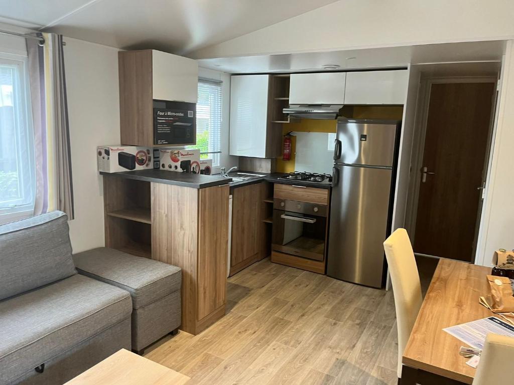une petite cuisine avec une table et un réfrigérateur dans l'établissement MH 385 3 chambre ET 1 salle de bain 40M2 dans camping 4 étoiles, à Saint-Julien-en-Born