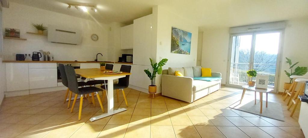 une cuisine et un salon avec une table et un canapé dans l'établissement T2 de 56m2 - Genève à 5 min- Parking Privé Gratuit, à Saint-Julien-en-Genevois