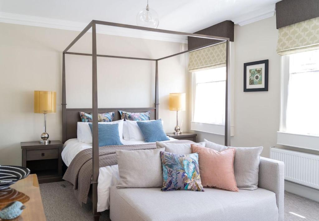 a bedroom with a large bed and a couch at Bespoke Central Town House in Bath