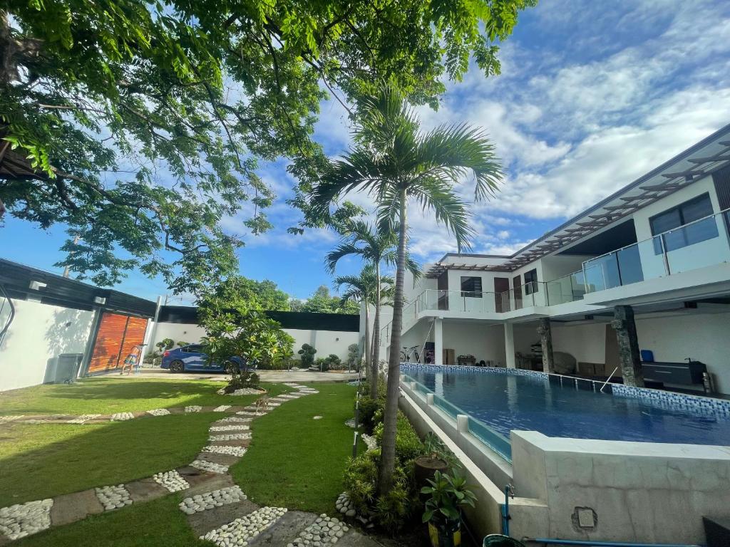 a house with a swimming pool and a palm tree at Caloocan Private Resort in Manila