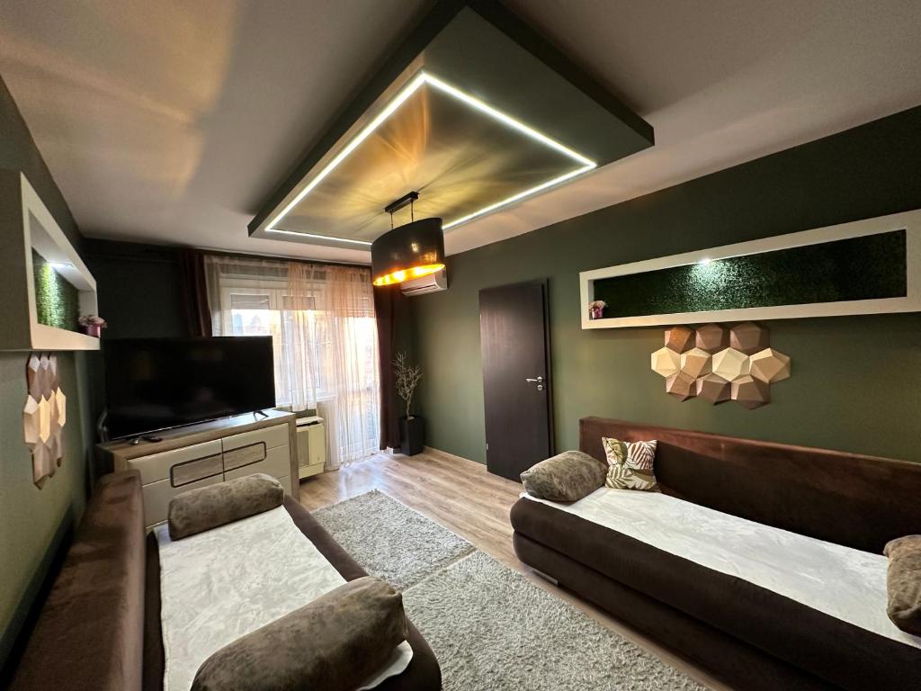 a living room with a couch and a television at Mox Downtown Apartman in Debrecen