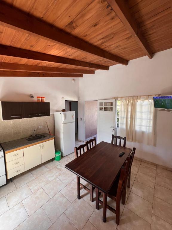 Una gran cocina con una mesa y sillas de madera. en La frontera chalet, en Las Toninas