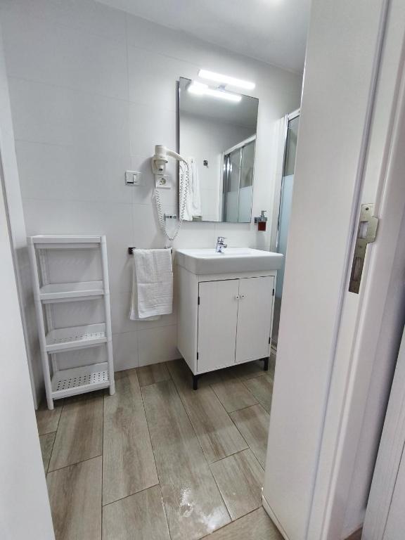biała łazienka z umywalką i lustrem w obiekcie Apartamento Salinas w mieście Pozo Izquierdo