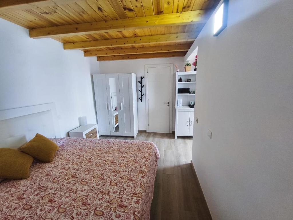 sypialnia z łóżkiem i drewnianym sufitem w obiekcie Apartamento Salinas w mieście Pozo Izquierdo