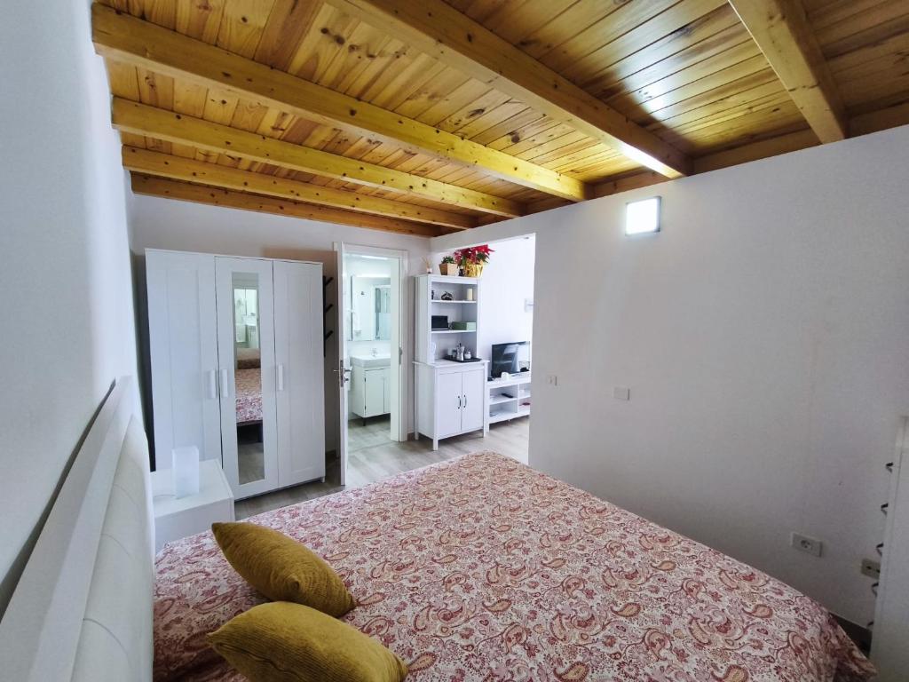 sypialnia z łóżkiem i drewnianym sufitem w obiekcie Apartamento Salinas w mieście Pozo Izquierdo