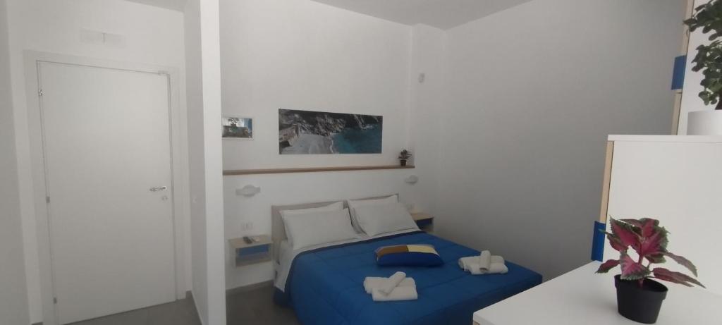 een kleine slaapkamer met een bed met blauwe lakens en witte kussens bij Alta Quota RELAX on the SEA in Salerno