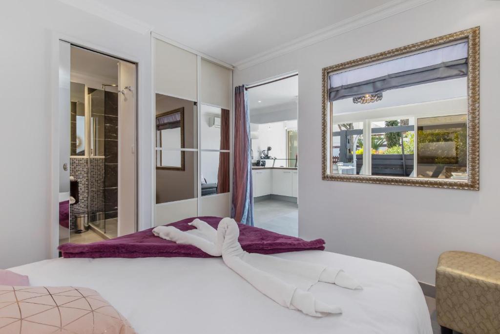 une chambre avec un grand lit blanc et un miroir dans l'établissement Village Naturiste R4N - Delizzia Villa Port Nature, au Cap d'Agde