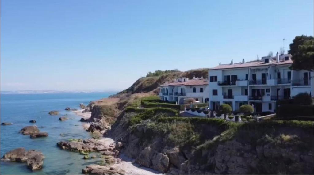 a building on a cliff next to the ocean at Casa elegante in riva al mare in Vasto