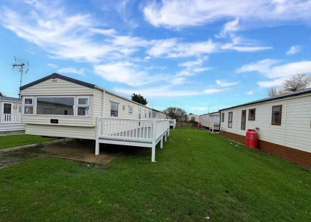 een rij stacaravans in een tuin bij 3 Bedroom 2 Bathroom Caravan Charlie Delta in Saint Osyth