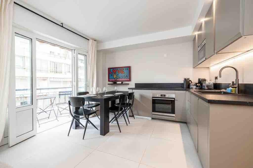 a kitchen with a table and some chairs in it at La suite Versailles Croisette in Cannes