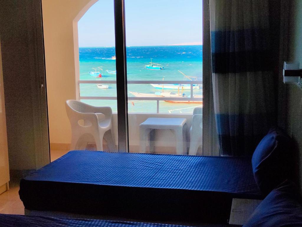 a bedroom with a window with a view of the ocean at Aquarium Seaview accomodations in Hurghada