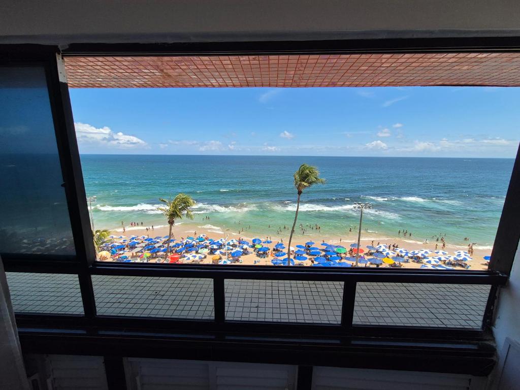 a view of a beach with umbrellas and the ocean at Farol Barra Flat in Salvador