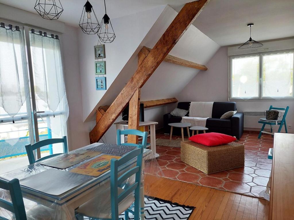 a living room with a table and chairs and a couch at Les Pins, plage à pied in Fouesnant