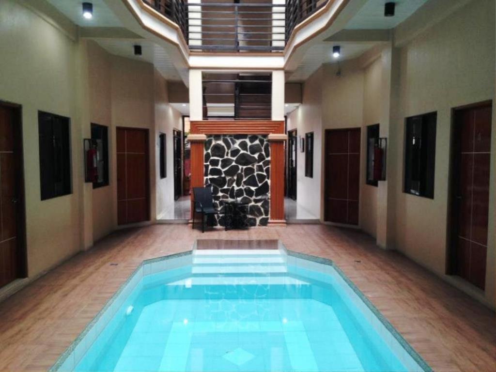 a large swimming pool in a room with a hallway at Hidden Pearl Hotel (Janus Luxury Suites) in Angeles