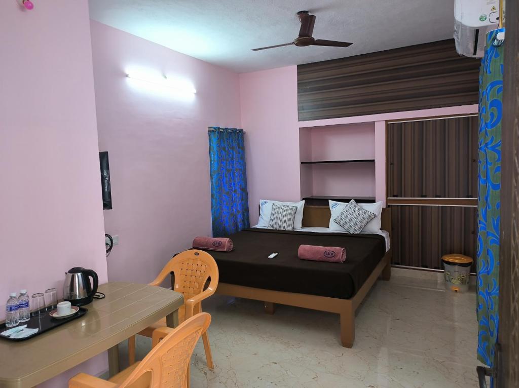 a small room with a bed and a table at La villa Rani KK Nagar in Madurai