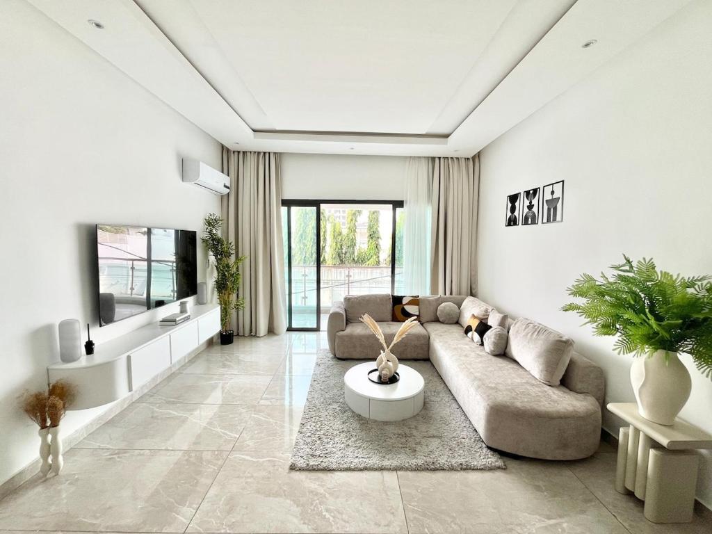 a living room with a couch and a tv at Jod & Naic Appartement in Abidjan