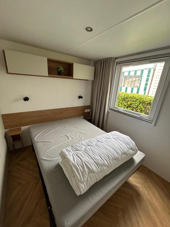 un petit lit dans une chambre avec une fenêtre dans l'établissement Elise&Kévin, à Pont-Aven