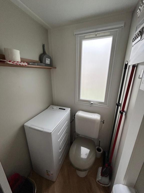 une petite salle de bain avec toilettes et fenêtre dans l'établissement Elise&Kévin, à Pont-Aven 4 autres photos