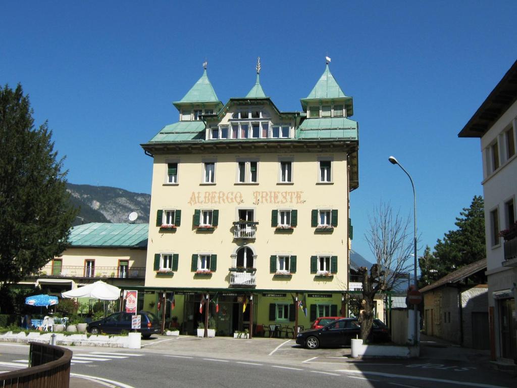 un gran edificio blanco con una torre encima en Albergo Trieste, en Lorenzago