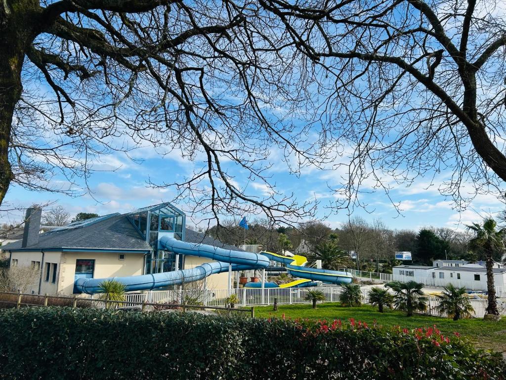 une aire de jeux avec un toboggan bleu dans un parc dans l'établissement Elise&Kévin, à Pont-Aven