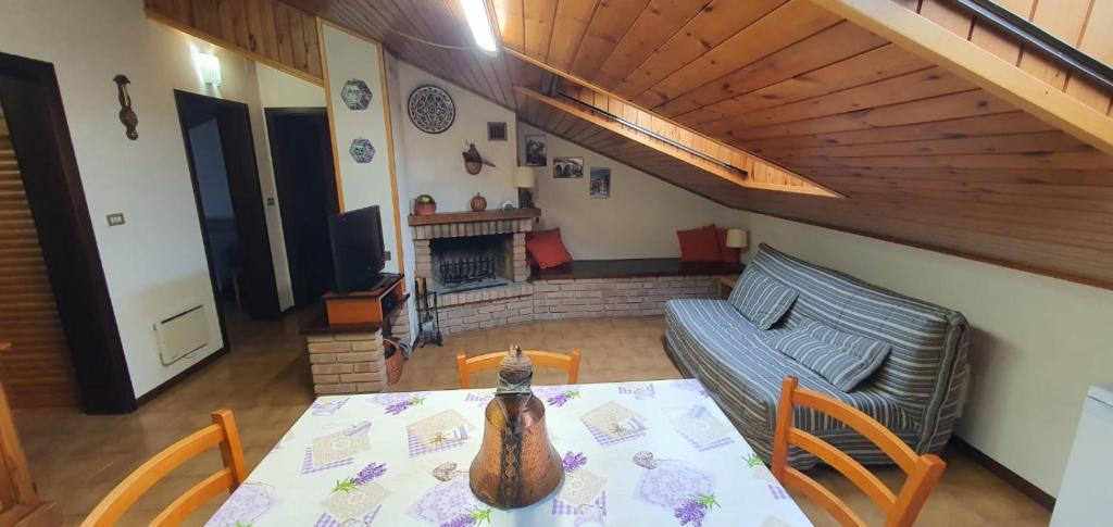 a living room with a table and a couch at Mansarda Elena in Sestola