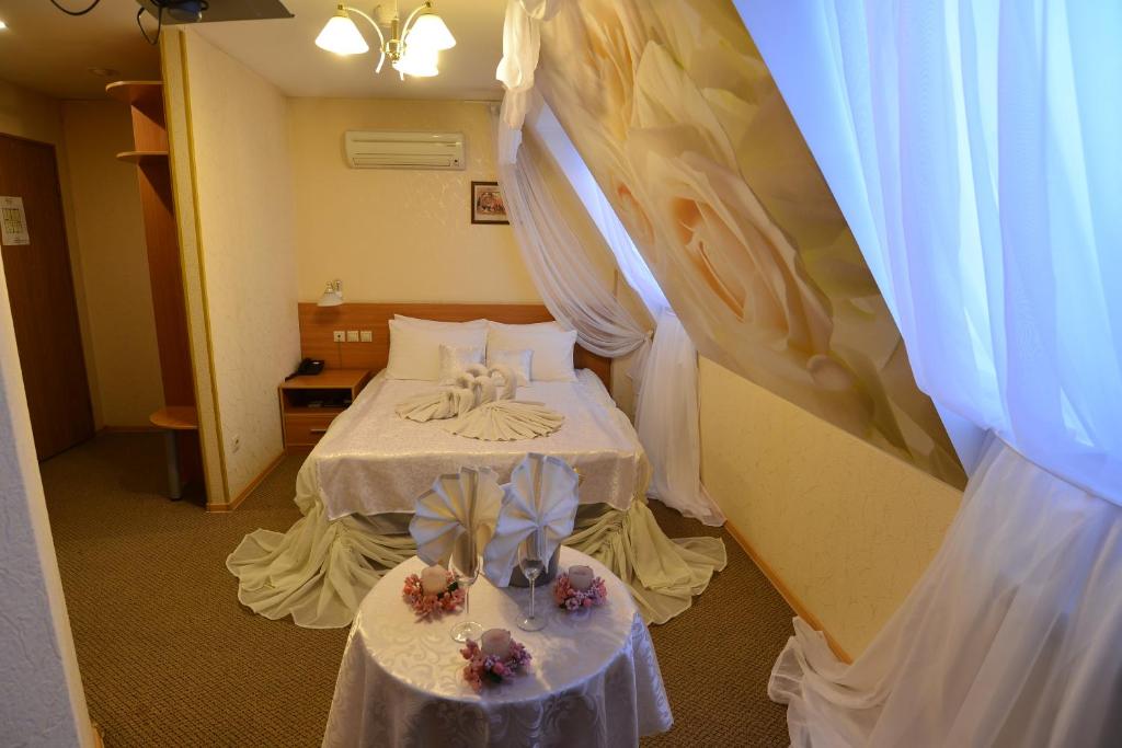 Una habitación con una cama con dos mesas. en Eurohotel Southern, en Yekaterinburg