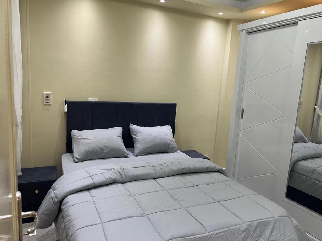une chambre avec un grand lit et un placard dans l'établissement comfort, à Madinaty