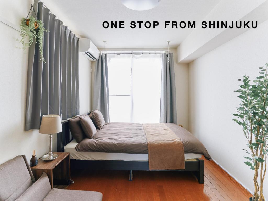 a bedroom with a bed and a couch at Evergreen Apartment Hotel in Tokyo