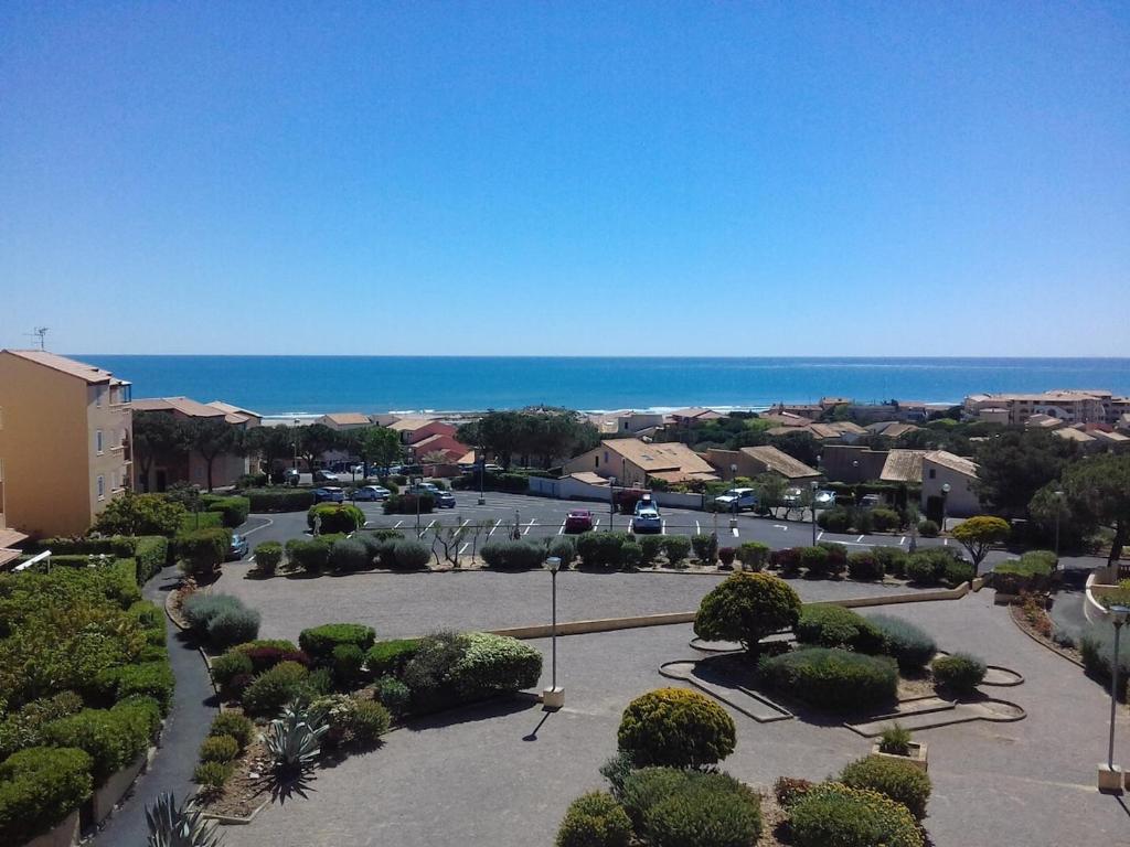 - une vue sur un parking avec l'océan en arrière-plan dans l'établissement Appartement St pierre la mer, à Fleury