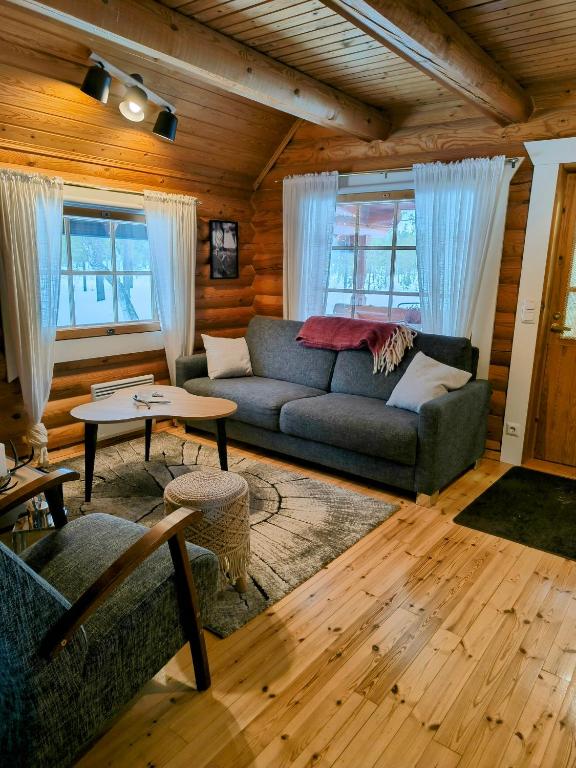 a living room with a couch and a table at Vähäreinari, mökki Ylläksellä - uudet varaukset syyskuusta 2025 alkaen sisältävät liinavaatteet ja loppusiivouksen in Ylläsjärvi