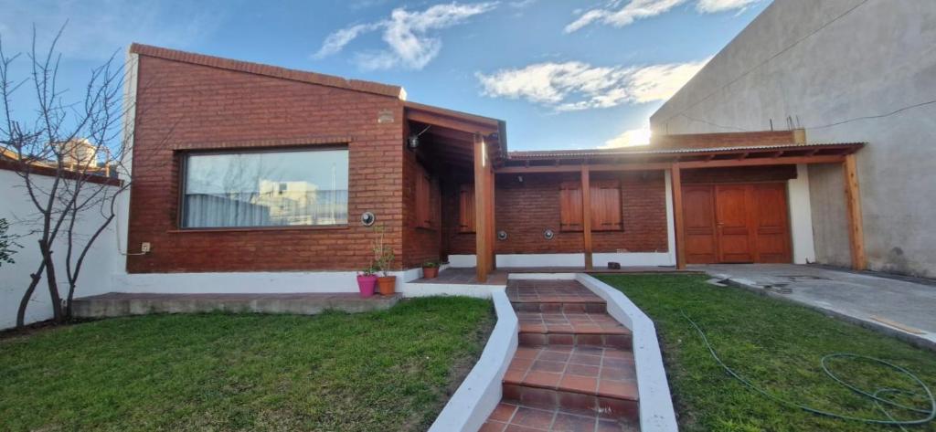 una casa in mattoni con un passaggio in mattoni nel cortile di Patagonia House a Rada Tilly