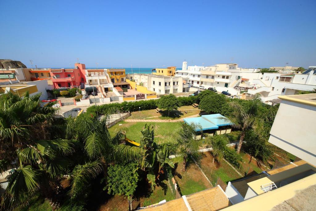 une vue aérienne sur une ville avec des palmiers et des bâtiments dans l'établissement Residence Rivamare Ugento, à Torre Mozza